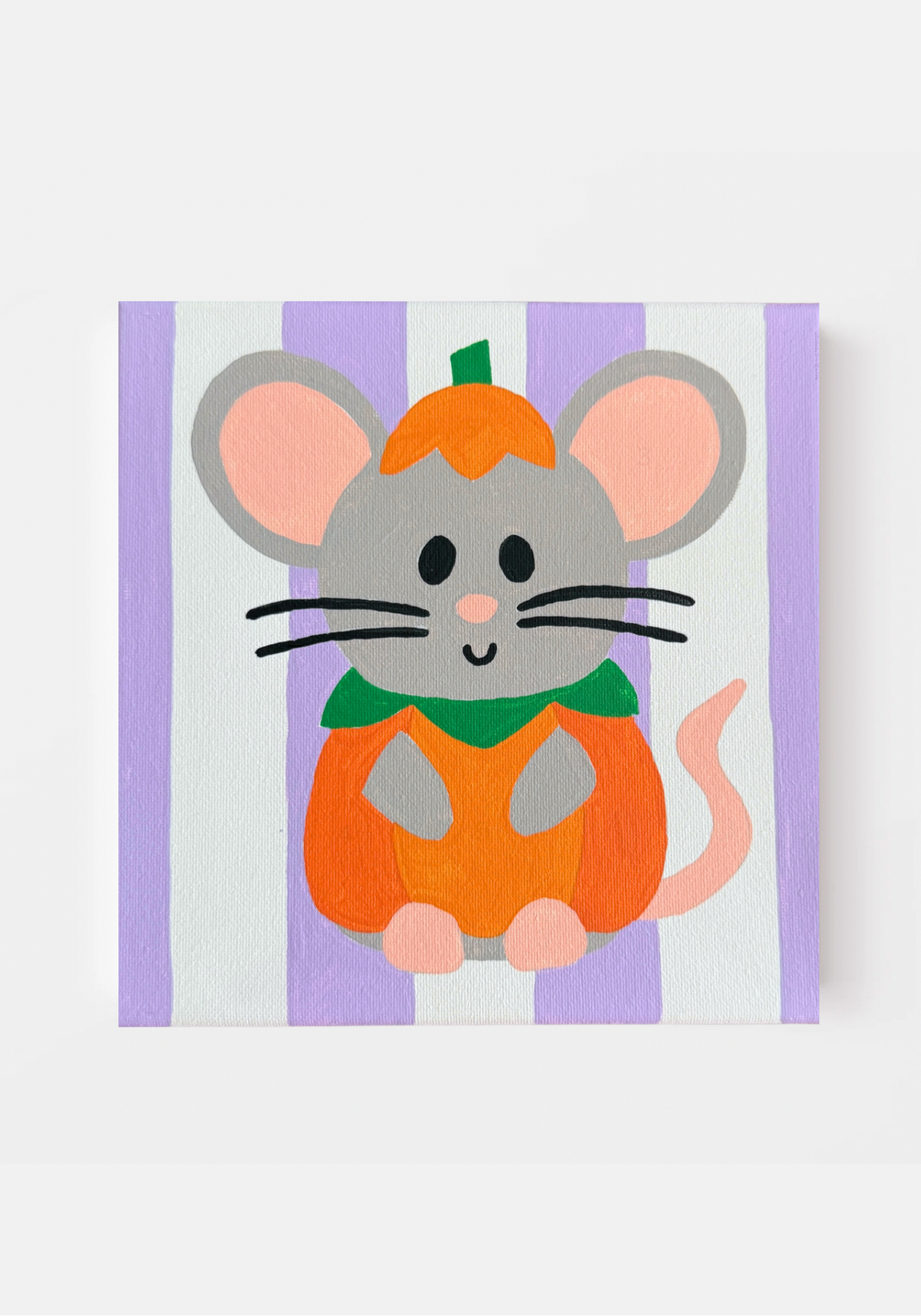A painted square canvas hanging on a white wall of a grey mouse wearing a pumpkin costume in front of a purple striped background.