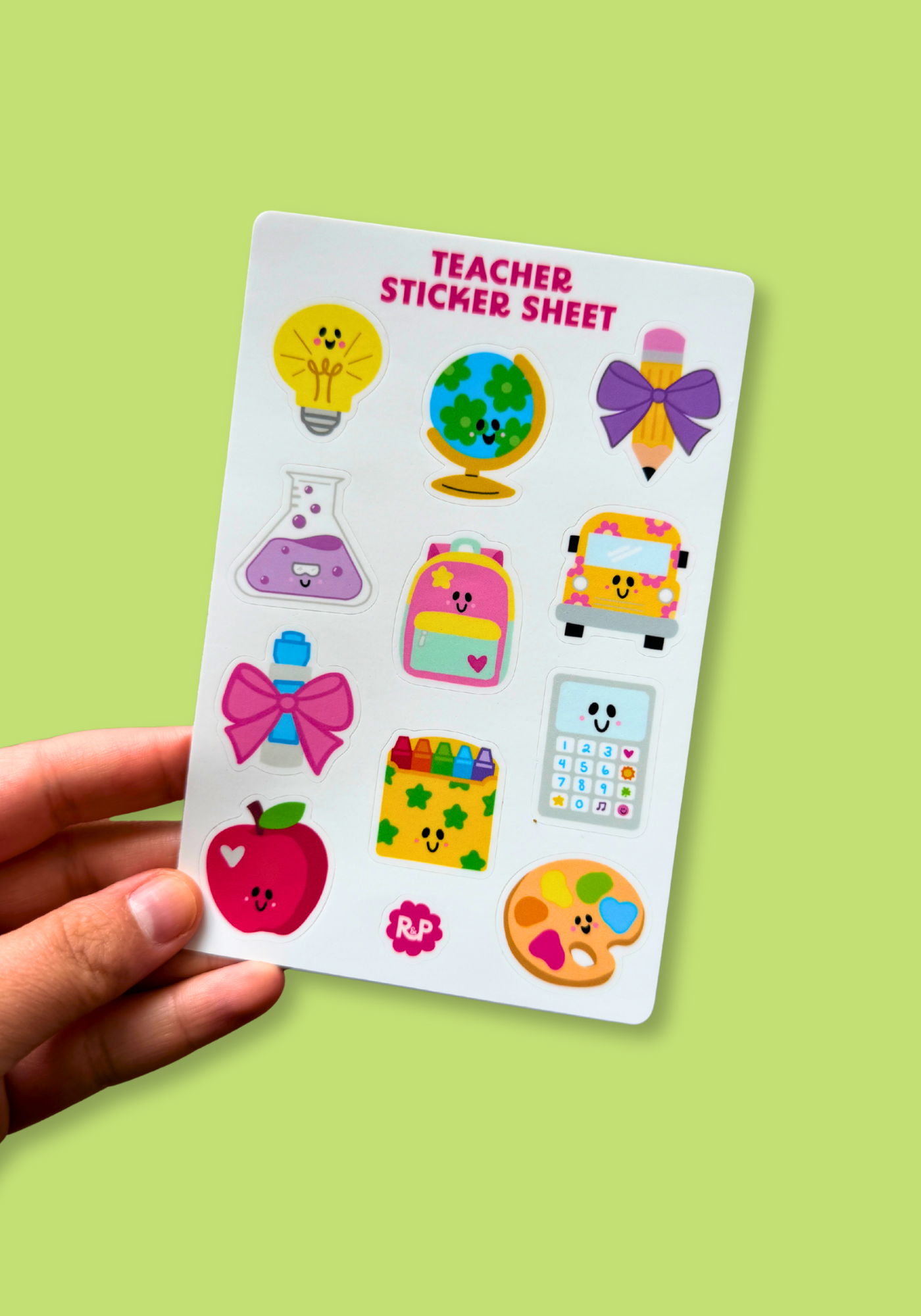 Sheet of colorful teacher-themed stickers held by a hand on a green background